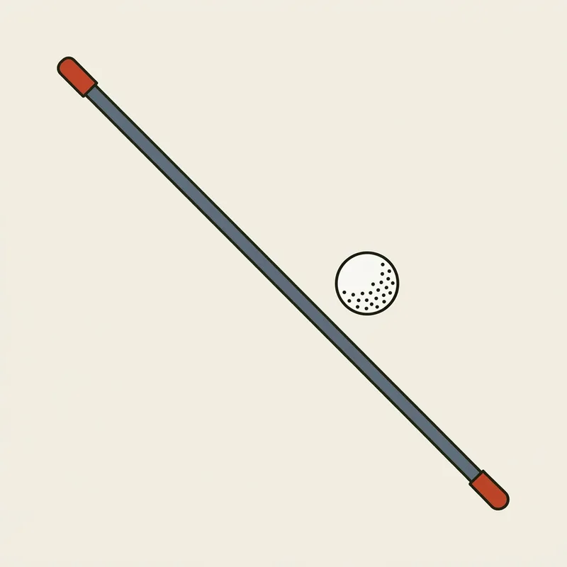 A single alignment stick lying flat on the ground with a golf ball beside it