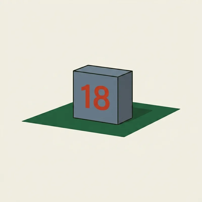 A tee marker block numbered 18 sitting on a square patch of short grass