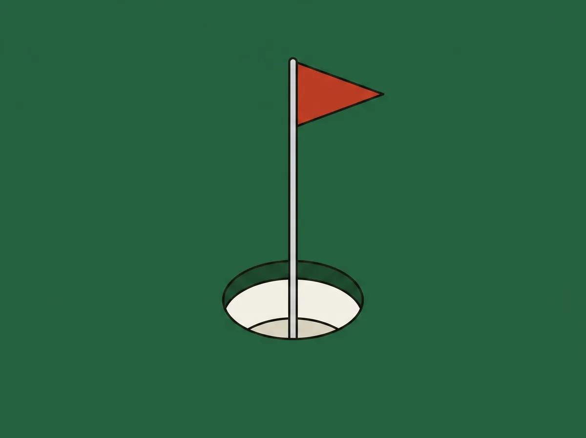 A golf hole cut into a putting green with the flagstick standing in it, seen from close and slightly above