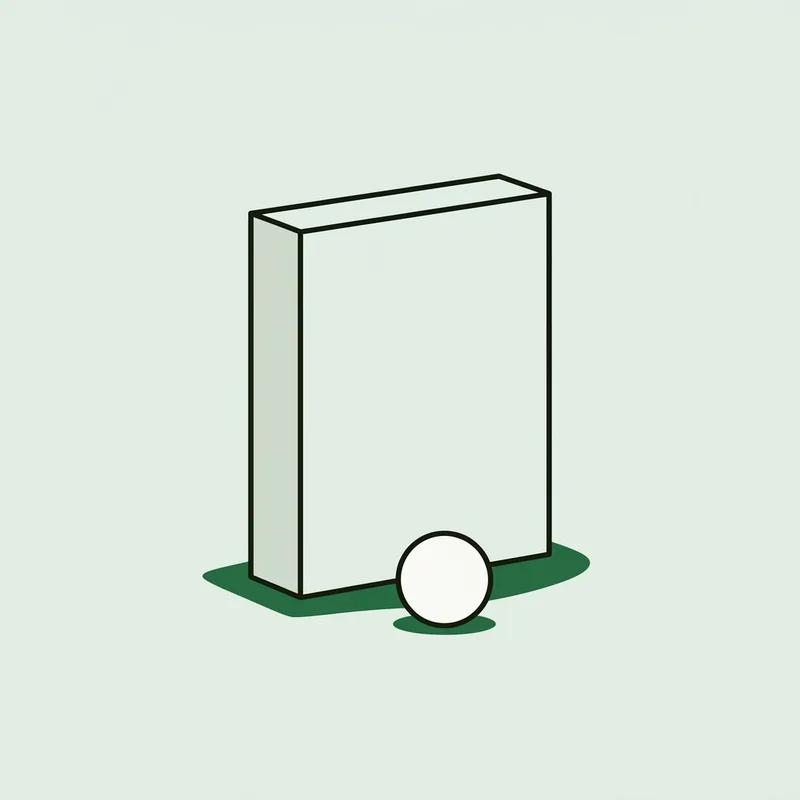 A small plain rectangular electronic device standing on short grass behind a golf ball